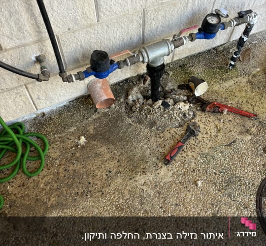 צינורות מים, ברזים וכלי עבודה על הקרקע